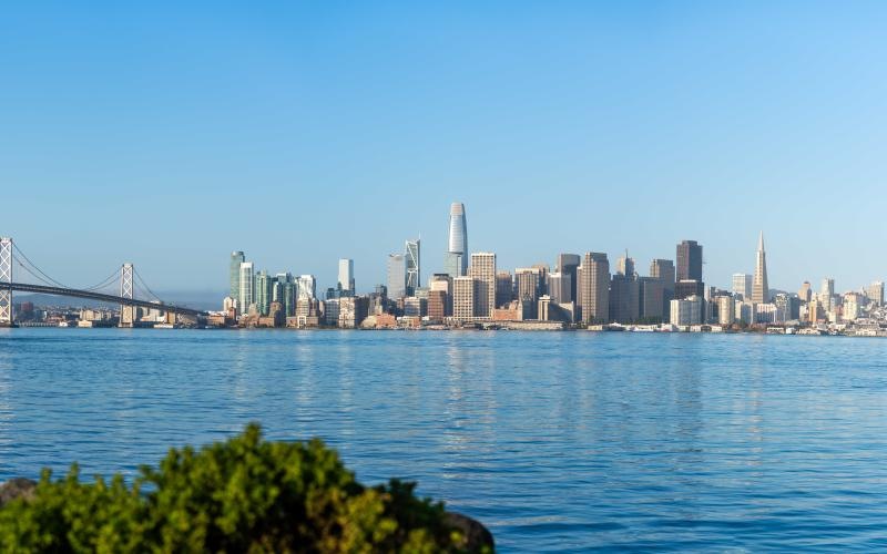 a bridge over a body of water with a city in the background